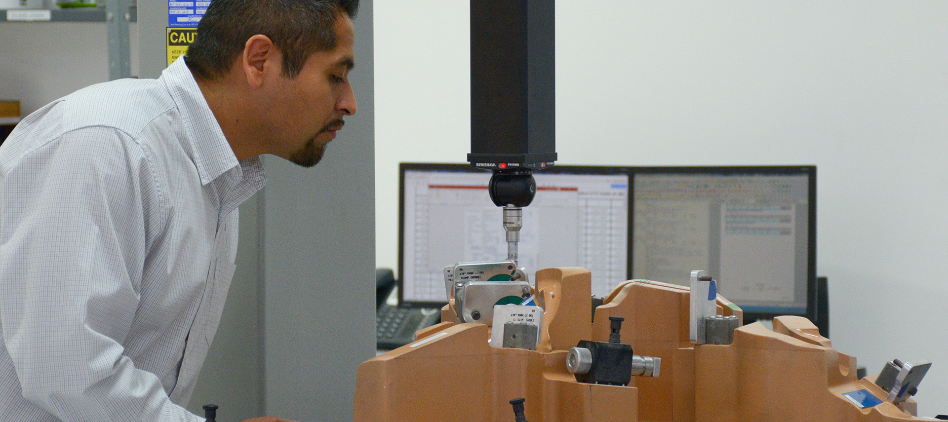 CMM Inspection Technician looking at a measuring device